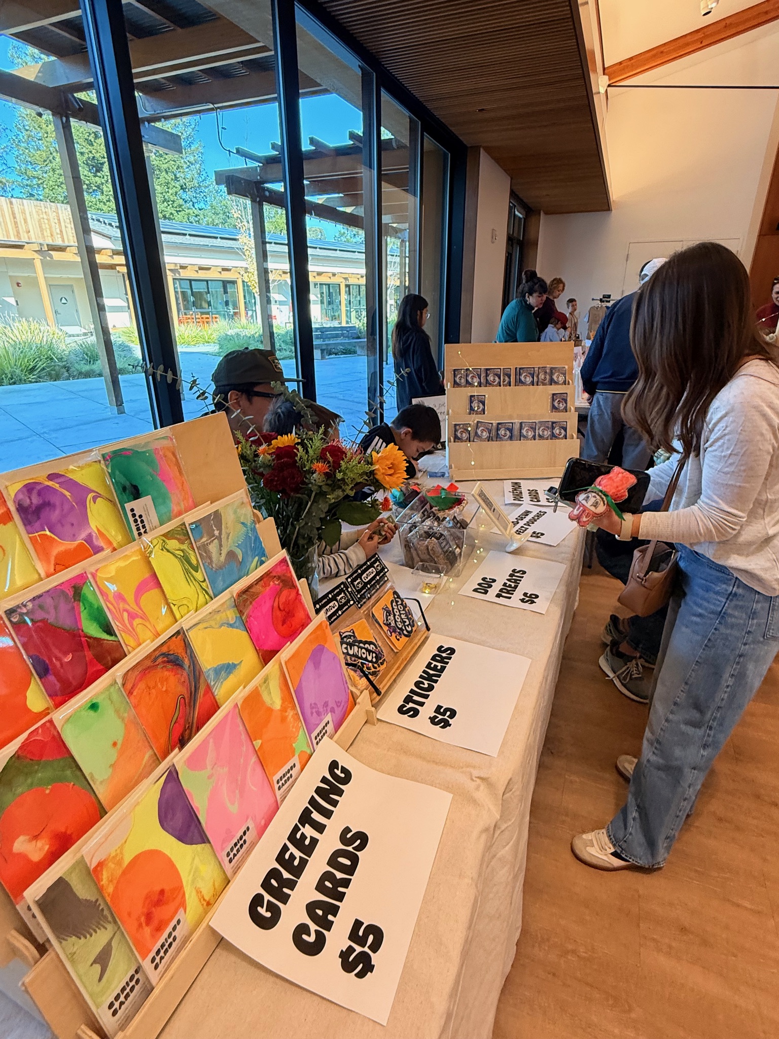 Curious Cards display at market — rows of vibrant handmade marbled greeting cards